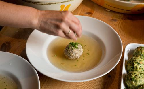 Traditionelle Südtiroler Knödelsuppe wird serviert – regionale Küche Traditionelle Südtiroler Knödelsuppe wird serviert – regionale Küche